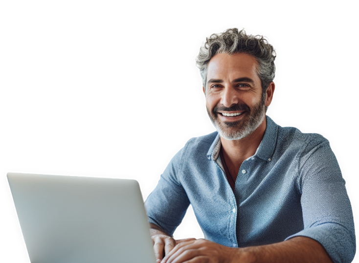 Un uomo con i capelli grigi e una barba sorride mentre usa un laptop